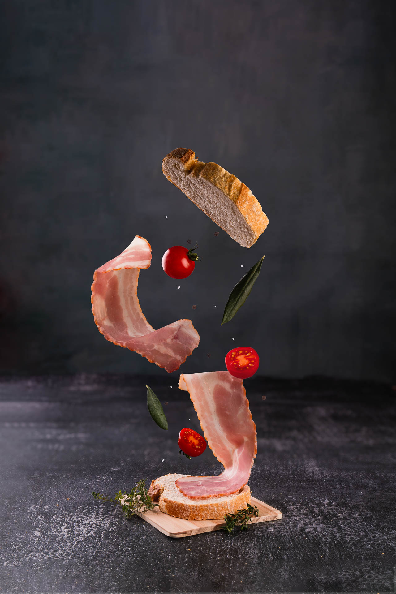 fotografia comercial porto de bacon e pão a levitarem em fundo cinzento