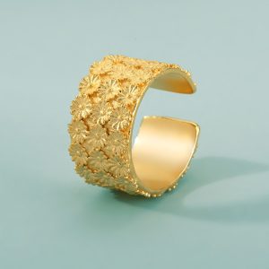 fotografia de anel de ouro com flores em fundo verde